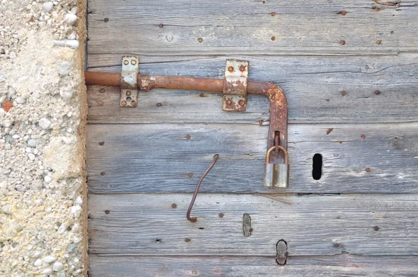 Antiguo, abandonado, gris, puerta de madera con candado — Foto de Stock