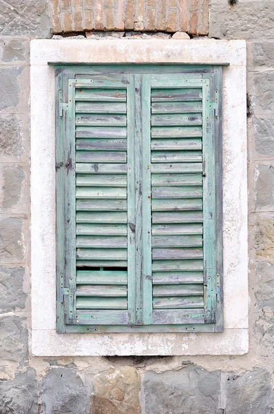 Ventana vieja con persianas azules cerradas en una casa vieja — Foto de Stock