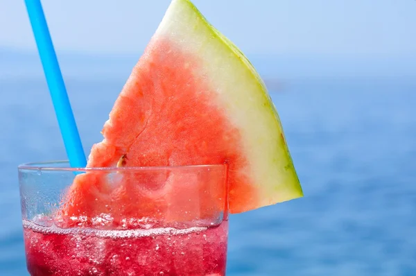 Cocktail de frutas tropicais frescas com fatia de melancia em uma praia — Fotografia de Stock