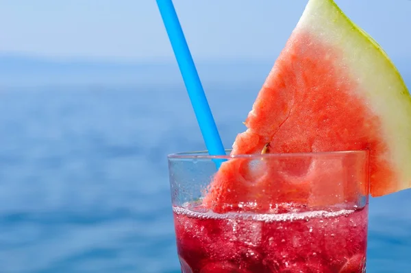 Cocktail de frutas tropicais frescas com fatia de melancia em uma praia — Fotografia de Stock