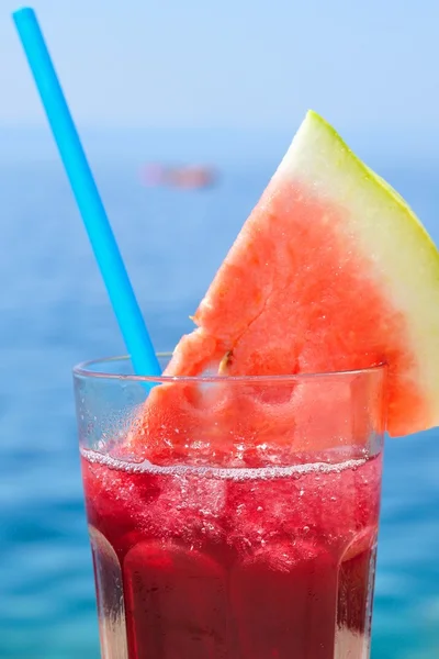 Cocktail de frutas tropicais frescas com fatia de melancia em uma praia — Fotografia de Stock