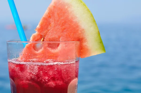 Cocktail de frutas tropicais frescas com fatia de melancia em uma praia — Fotografia de Stock