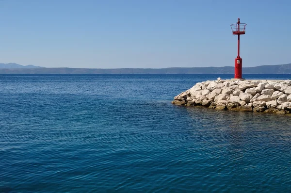 Красный маяк в порту — стоковое фото