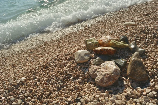 Pietre sulla spiaggia con onda — Foto Stock