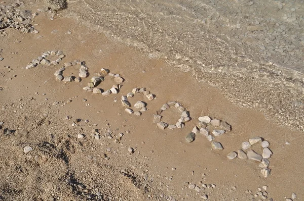 Slovo podgora se uvádí s oblázky na pláži — Stock fotografie