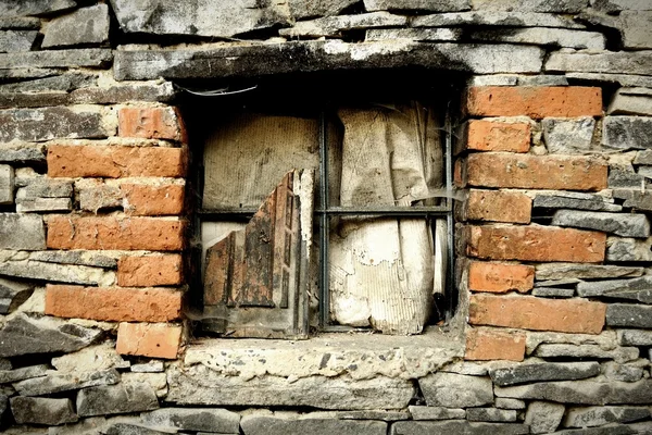 Vieja ventana devastada en un muro de piedra — Foto de Stock