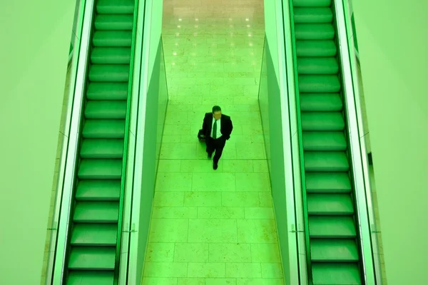 Businessman between two escalators — Stock Photo, Image