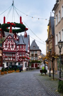 Noel süslemeleri kaldırım taşı sokağında asılı duruyor. Alte Haus, Eski Ev, Bacharach, Almanya 'da arka planda bulutlu bir sonbahar gününde..