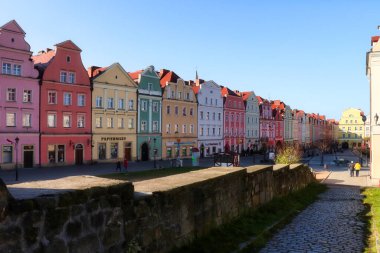 Row of colorful buildings in a square in Boleslawiec, Poland on a sunny fall day.