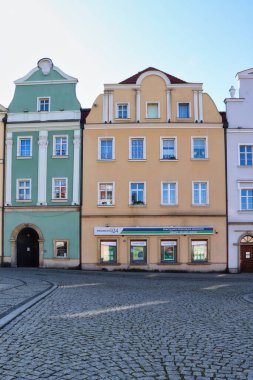 Polonya 'nın Boleslawiec şehrinde sonbahar günü küçük yeşil bir binanın yanındaki sarı bina..