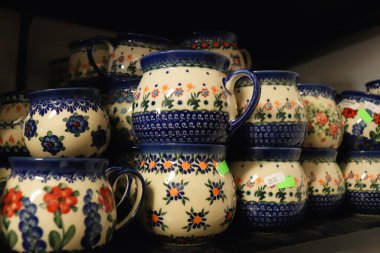 Polonya 'nın Boleslawiec kentindeki bir mağazanın rafında el yapımı Polonya çömlek bardakları..