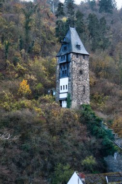 Almanya 'nın Bacharach kentinde, bir sonbahar günü, ağaçlarla kaplı bir tepede kule..