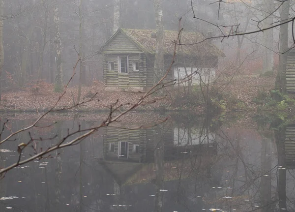 Hütte Und Spiegelung Seewasser Umgeben Von Bäumen Und Blättern Boden — Stockfoto