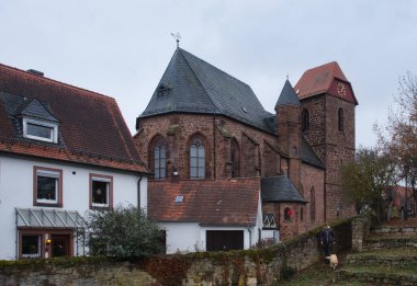 Neuleiningen, Almanya - 2 Aralık 2020: Bulutlu bir sonbahar gününde Neuleiningen Kalesi 'ndeki kaya duvarının yanındaki St. Nikolaus Kilisesi.