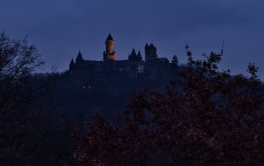 Braunfels, Germany - December 9, 2020: Light shining on a tower of Braunfels castle on a dark fall night in Germany.