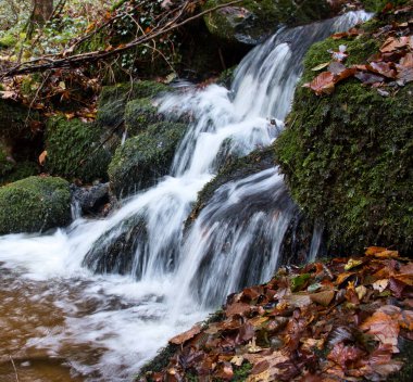 Water splashing as it cascades over rocks in a small waterfall at Gaisholl waterfalls in the Black Forest of Germany.