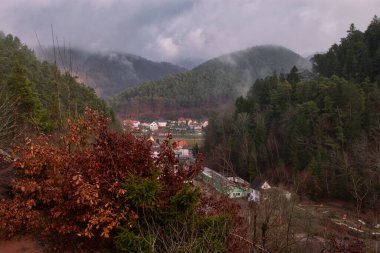 Hiinterweidenthal, Almanya - 1 Ocak 2021: Almanya 'da soğuk bir kış gününde Keltenbach' ı çevreleyen dağların üzerinde sis.