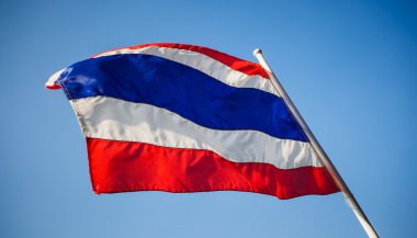Mavi gökyüzü arka plan ile Tayland Tayland bayrağı sallayarak resim