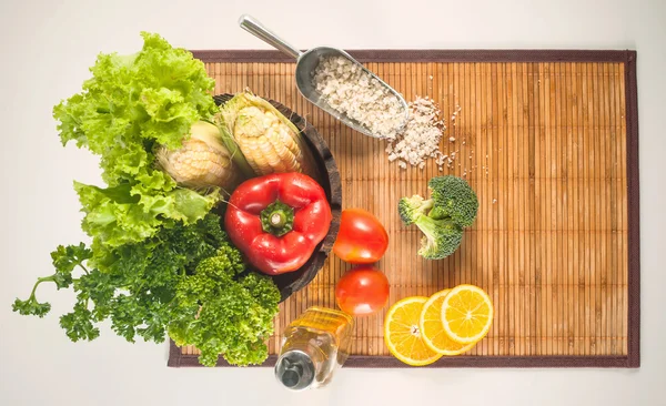 Färska grönsaker och andra råvaror på en bambu matta — Stockfoto