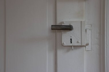 Eski bir antika yüzey monte edilmiş kilit kutusu. Kopya alanı olan beyaz, ahşap bir kapı.