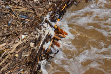 Sel sırasında odun yığını ve plastik çöp, çevresel su kirliliği