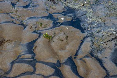 Black and brown sand forming a natural pattern during low tide in the north sea