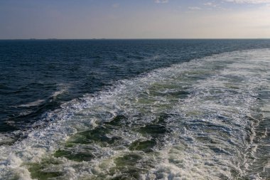 Wake behind a ship reflecting the sun