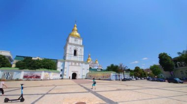 KYIV, UKRAINE - 23 Temmuz 2021: St. Michael 's Altın Kubbeli Manastır çan kulesinin geniş açı görüntüleri büyük meydanda kiralık elektrikli scooter ile