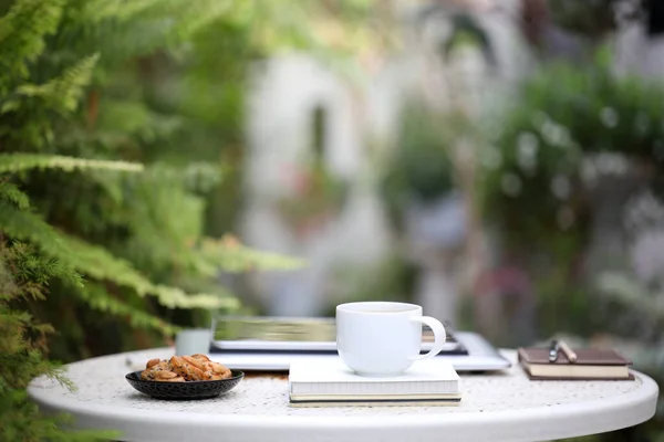 Tazza Caffè Bianco Con Biscotti Quaderni Tablet Sul Tavolo Bianco — Foto Stock