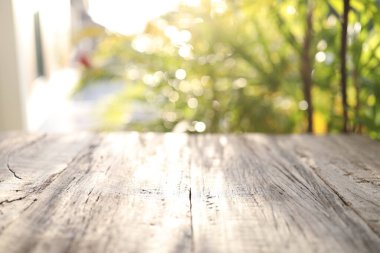 Güneş ışığı ve bulanık yeşil arkaplan ile ahşap yüzey görüntüsü