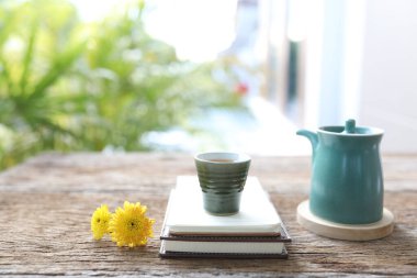 Seramik çay fincanı ve mavi antika çaydanlık ve çiçekler.