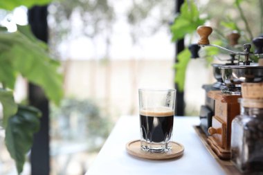 Beyaz masadaki ahşap tepside Espresso bardağı.