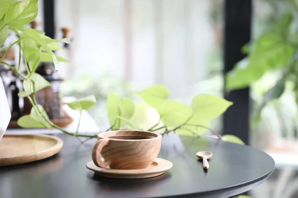 Wooden coffee cup and plant pot on black table indoor drinking