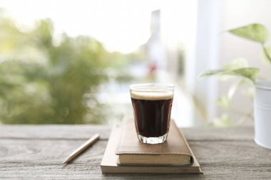 Kremalı kahve fincanı ve defterleri olan bir espresso.