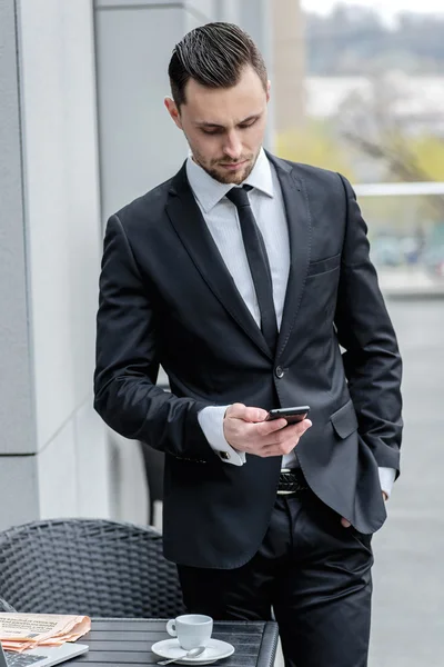 Call waiting. Young businessman in formal wear holding a cell ph
