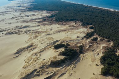 Curonian Gölünü Baltık Denizi 'nden ayıran dar ve uzun kumlu kılıç şeklinde bir kara şeridi manzarası. Curonian Tükürüğünün gri kum tepeleri.