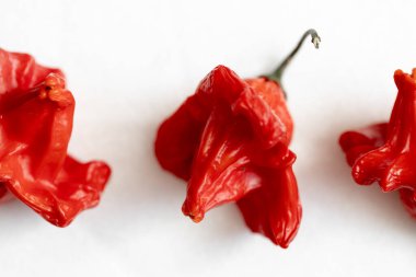 Beyaz arka planda kurutulmuş kırmızı Vezir biberi, parlak turbiber meyveleri, kırmızı biber, üst manzara.