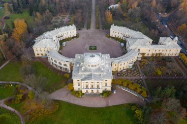 Pavlovsk Parkı ve Pavlovsk Sarayı 'nın sonbahar akşamları panoramik hava manzarası. Parlak sonbahar manzarası, Slavyanka nehri. St. Petersburg 'un bir banliyösü