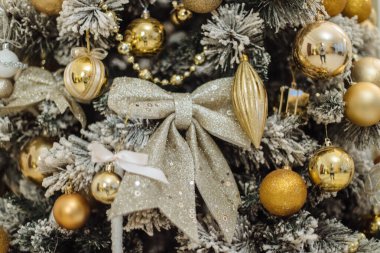 Noel ağacının arka planına oyuncaklarla yakın plan. Noel yaylı süsleme, köknar ağacı dalları. Noel dekoru. Kış tatili kavramı. Mutlu yıllar.