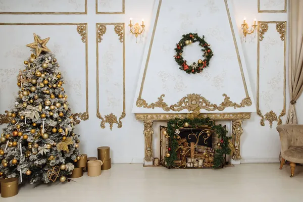 Yeni yıl içleri süslenmiş bir Noel ağacı ve oturma odasında beyaz tonlarda bir şömine, ağacın altında yeni yıl hediyeleri, evde şenlikli dekorasyonlar, Noel şöminesi dekoru.