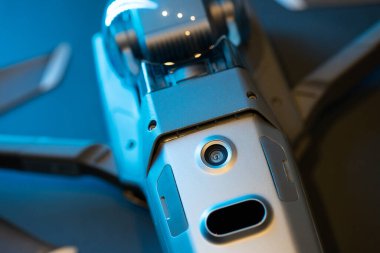 Mavi ışıkta siyah bir arkaplanda ters dönmüş bir Mavic 2 Pro quadcopter. Kızılötesi sensörler ve sensör sistemi, diyot lamba. Kopyalamak için boşluk