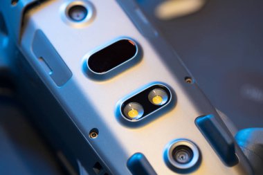 İnsansız hava aracının alt kısmının görüntüsü, diyot aydınlatma, kızılötesi engelleme algılayıcıları, kuadrokopter sensörleri. Dronun bakımı ve onarımı. Yakın plan, maviler içinde.