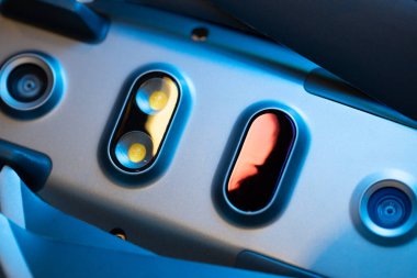 İnsansız hava aracının alt kısmının görüntüsü, diyot aydınlatma, kızılötesi engelleme algılayıcıları, kuadrokopter sensörleri. Dronun bakımı ve onarımı. Yakın plan, maviler içinde.