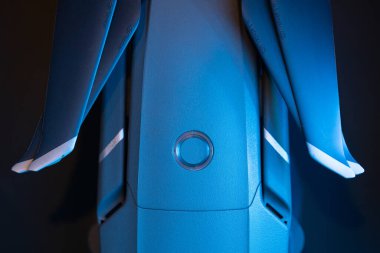 İHA gövdesinin üst görüntüsü, şarj göstergesi olan güç düğmesi, kuadkopterin içine yerleştirilmiş pil, drone pervaneleri. Mavi, yakın plan.