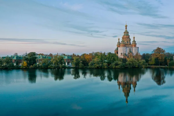 Olgas Pond and the Cathedral of Peter and Paul in Peterhof at sunset, the reflection of the sky and trees in the water, a church with domes, a photo for a postcard — 图库照片