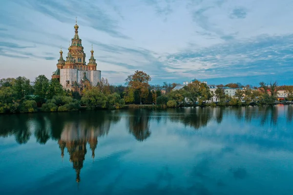 Olgas Pond and the Cathedral of Peter and Paul in Peterhof at sunset, the reflection of the sky and trees in the water, a church with domes, a photo for a postcard — 图库照片