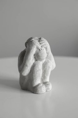 Oturup elleriyle gözlerini kapatan bir maymun heykeli. Ben bir şey görmüyorum..