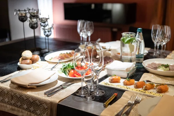 宴会やお祝いのためのテーブル設定 アルコール飲料のための空のガラス ワインとジュース テーブルを設定します テーブルの上に白い皿やカトラリーに布ナプキン — ストック写真