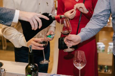 Garsonun biri yeşil masa ve kumarhane oyununun arka planına karşı bardağa kırmızı şarap dolduruyor. Bir adamın eli masaya şarap döker..