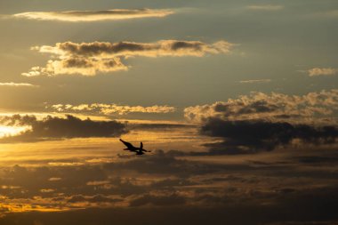 Dramatik bulutlar ve ışıkla akşam gökyüzü. Ladoga Gölü 'nün üzerinde çarpıcı bir gün batımı. Rüzgarda uçan bir martı..